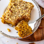 a square of pumpkin crumb cake with a fork taking a bite.