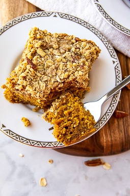 a square of pumpkin crumb cake with a fork taking a bite.