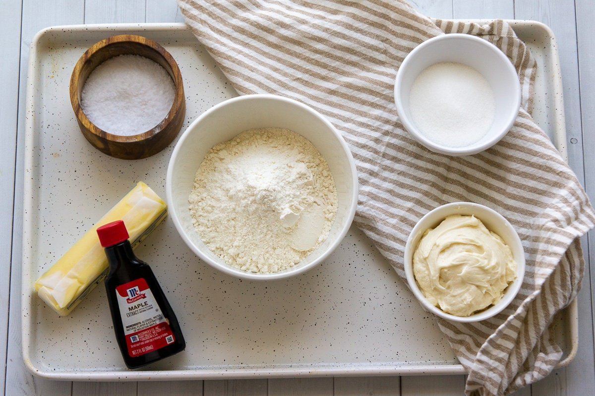 ingredients to make maple shortbread sandwich cookies including frosting, sugar, flour, butter, and maple extract.