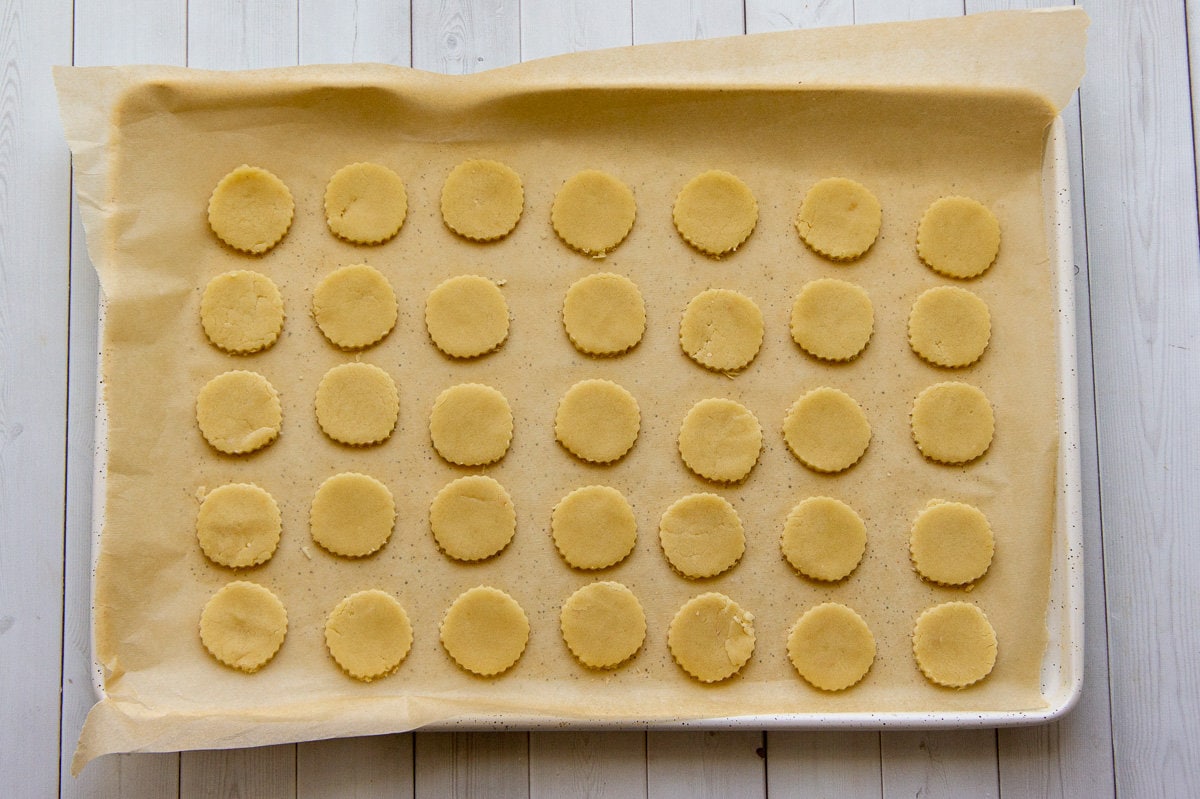 maple shortbread cut out and on a baking sheet.