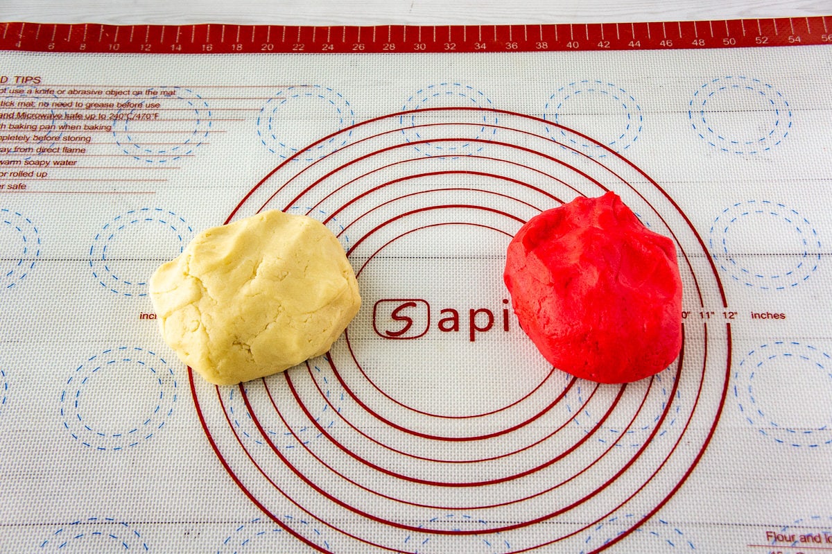 two balls of sugar cookie dough, one red and one white.