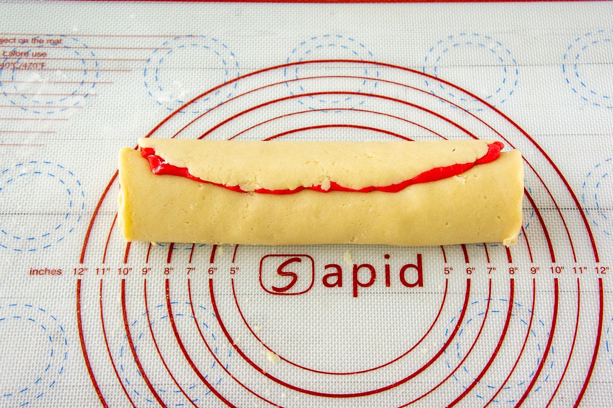 red and white sugar cookie dough rolled together in a log.