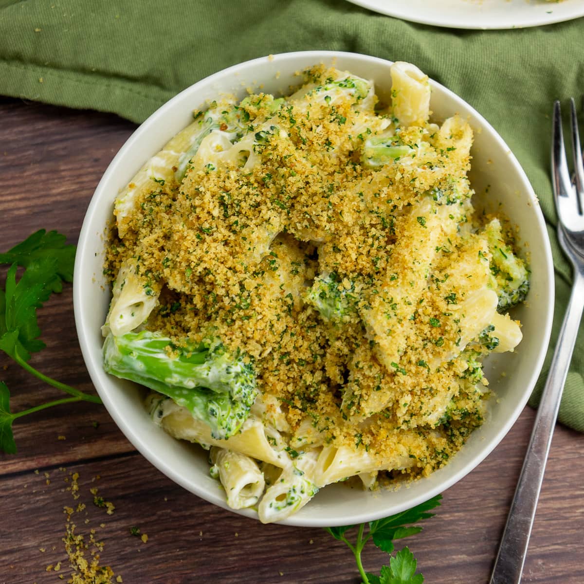 a bowl of creamy pasta with broccoli and breadcrumbs.
