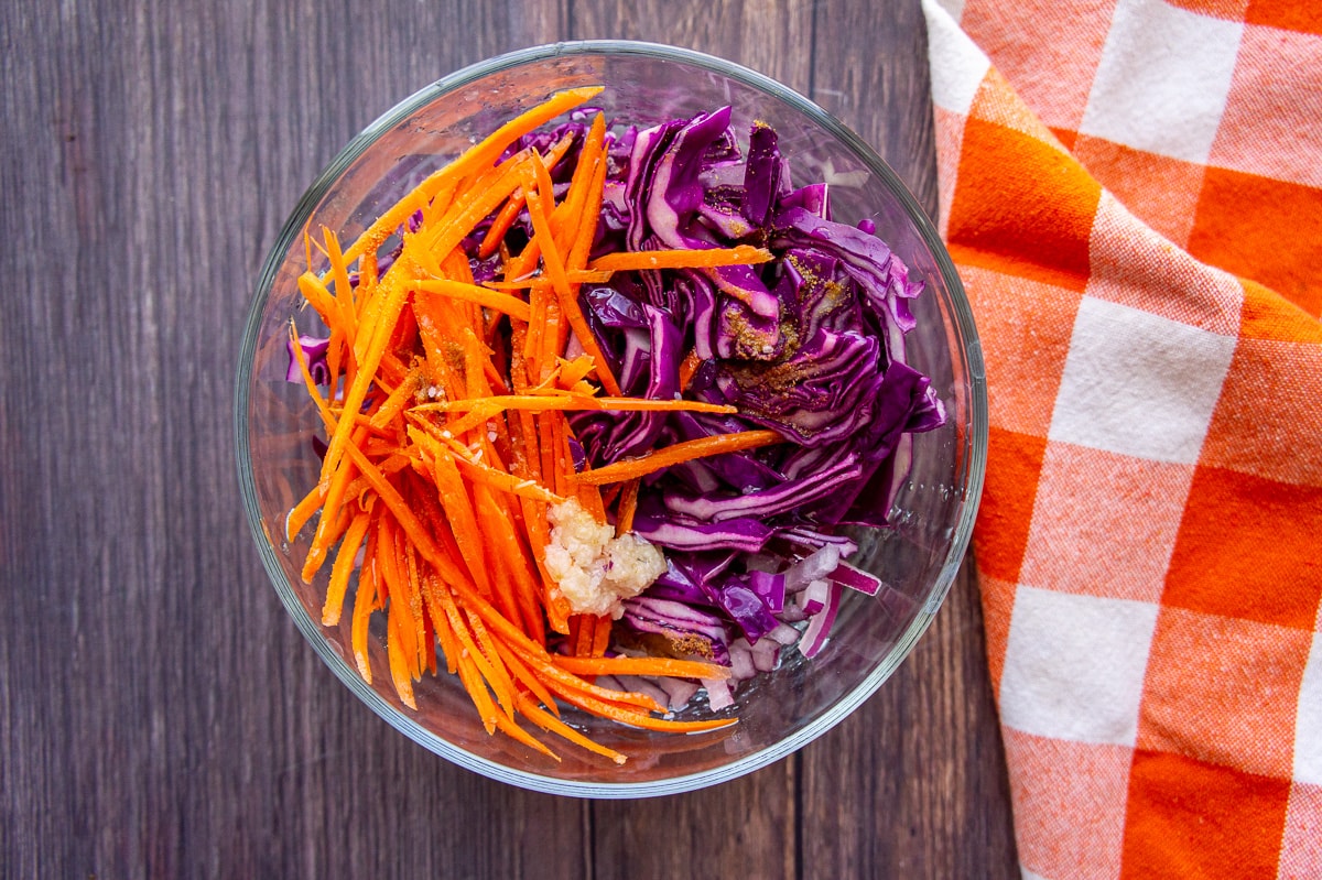 a bowl with thin carrots and sliced cabbage.
