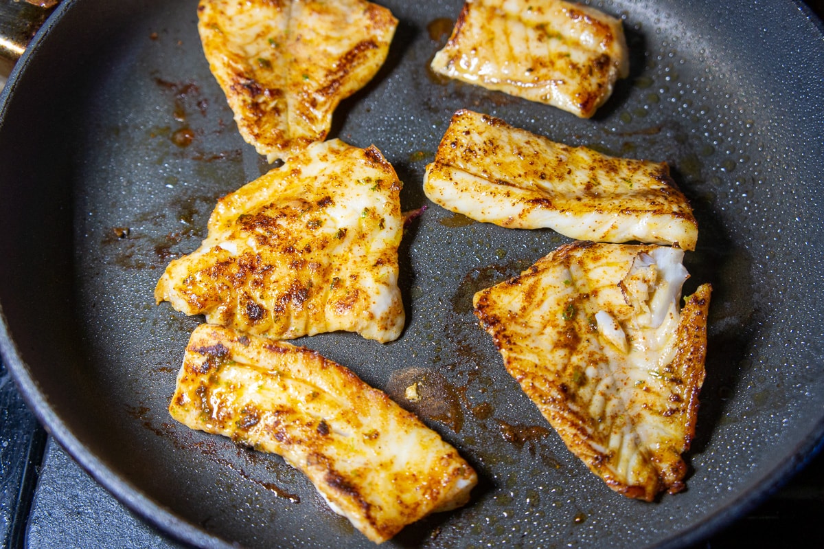 rockfish being cooked in a hot pan.