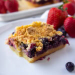 a berry crumble bar on a white plate