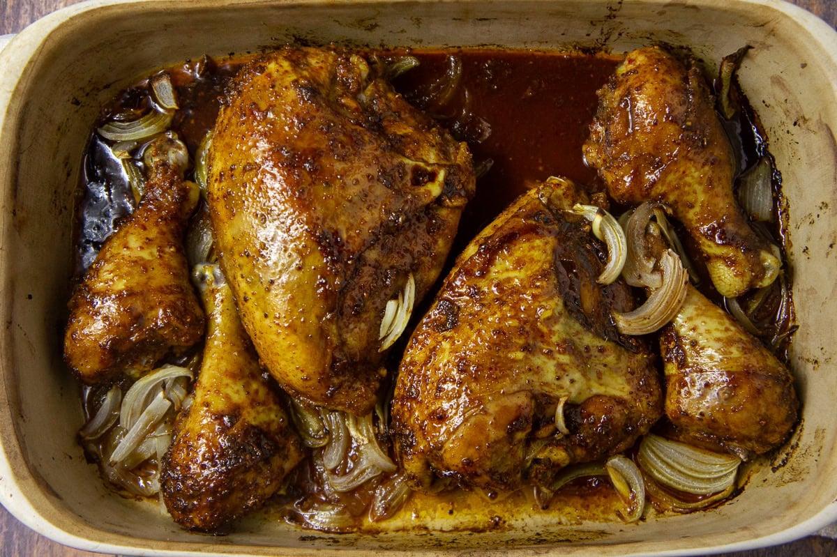 a pan of roasted bone in chicken and onions.