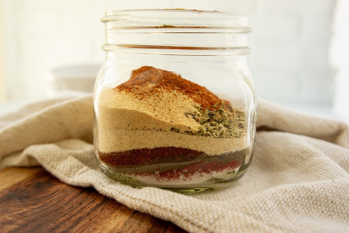 a mason jar with layers of spices inside.