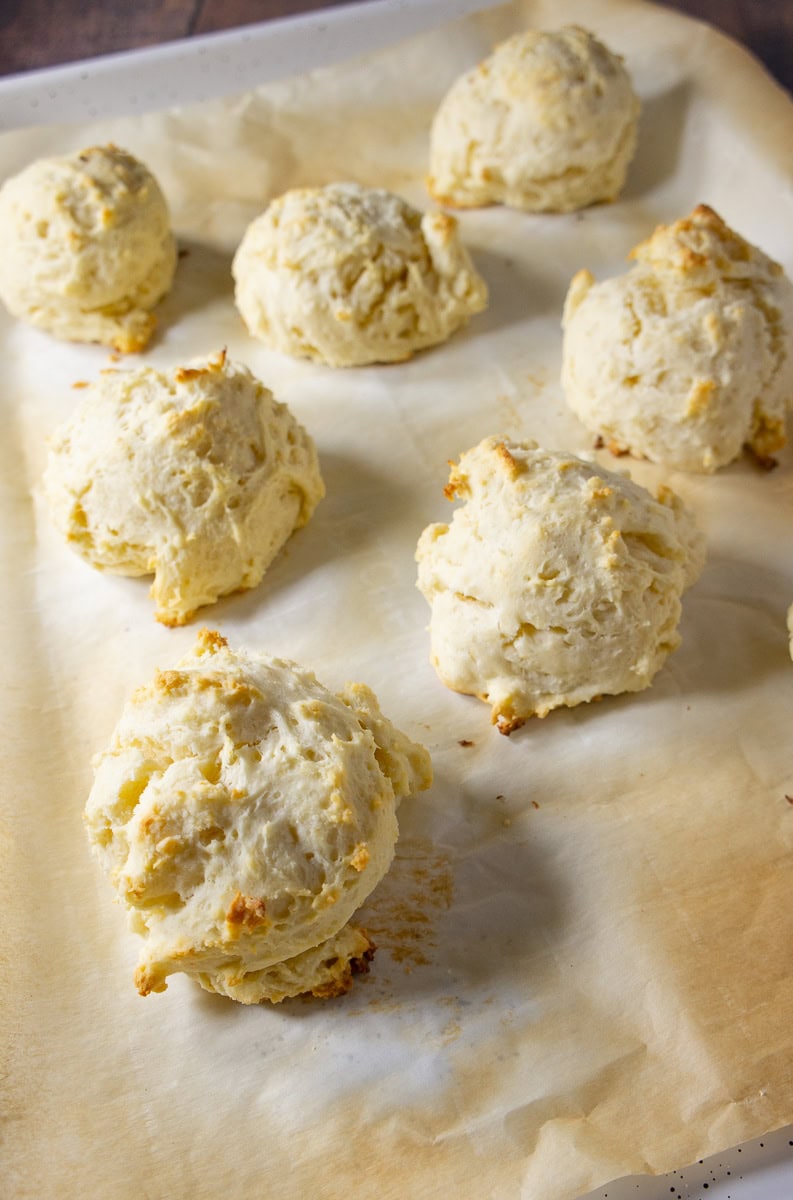 A baking sheet with drop biscuits baked on it.