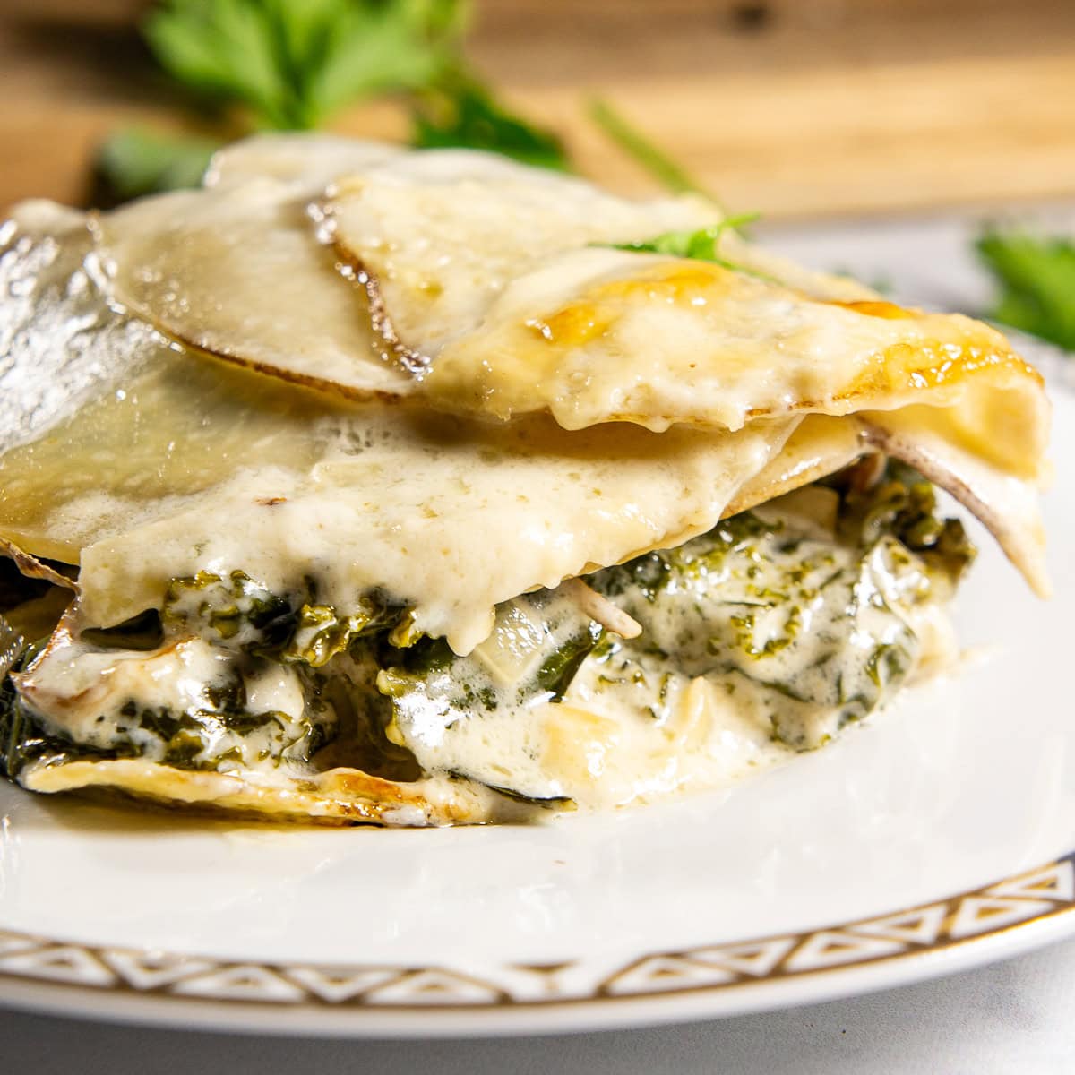 a slice of potato and kale gratin on a white plate.