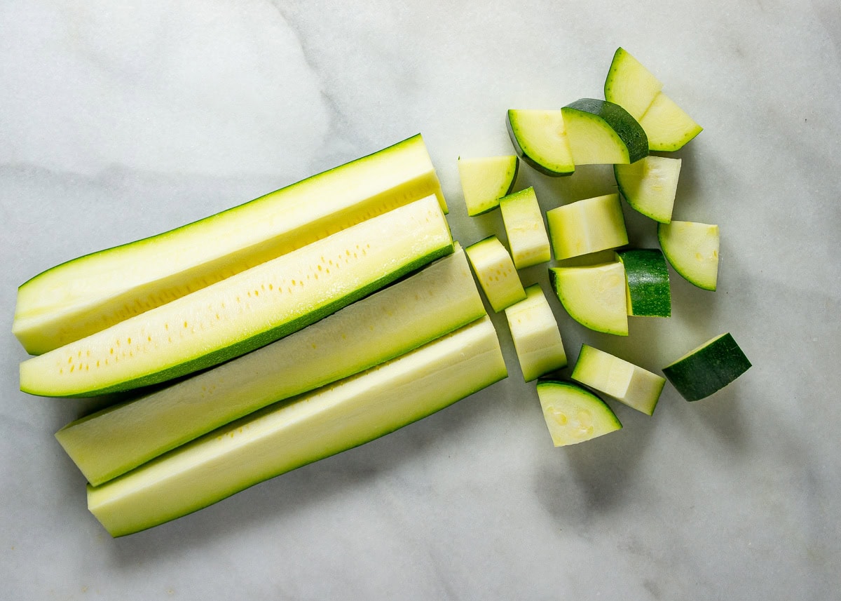 zucchini in quarters that are being cut into wedges.