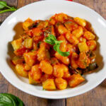 a large white bowl of gnocchi in a tomato basil sauce.