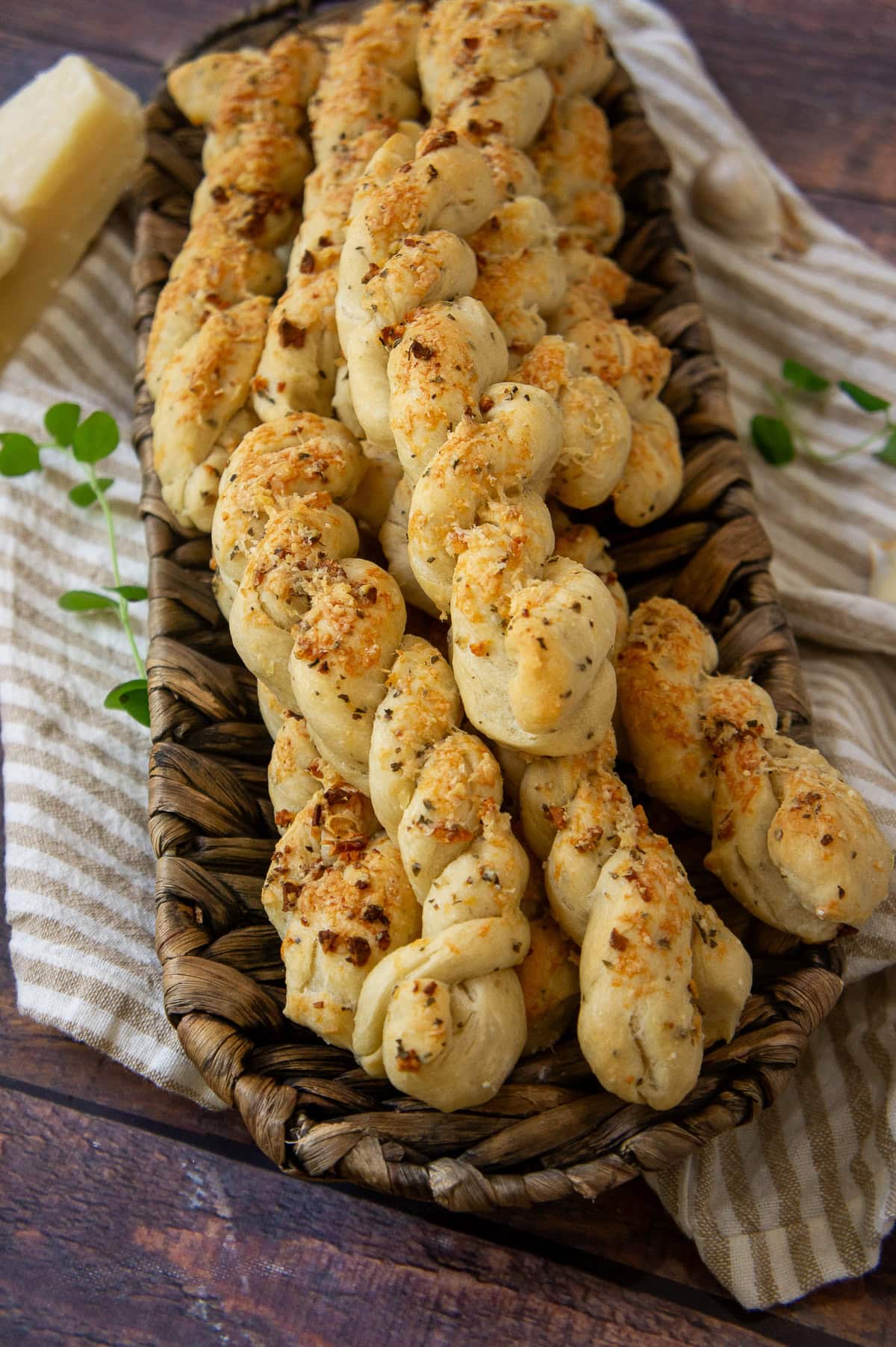 a platter of twisted breadsticks topped with browned cheese.